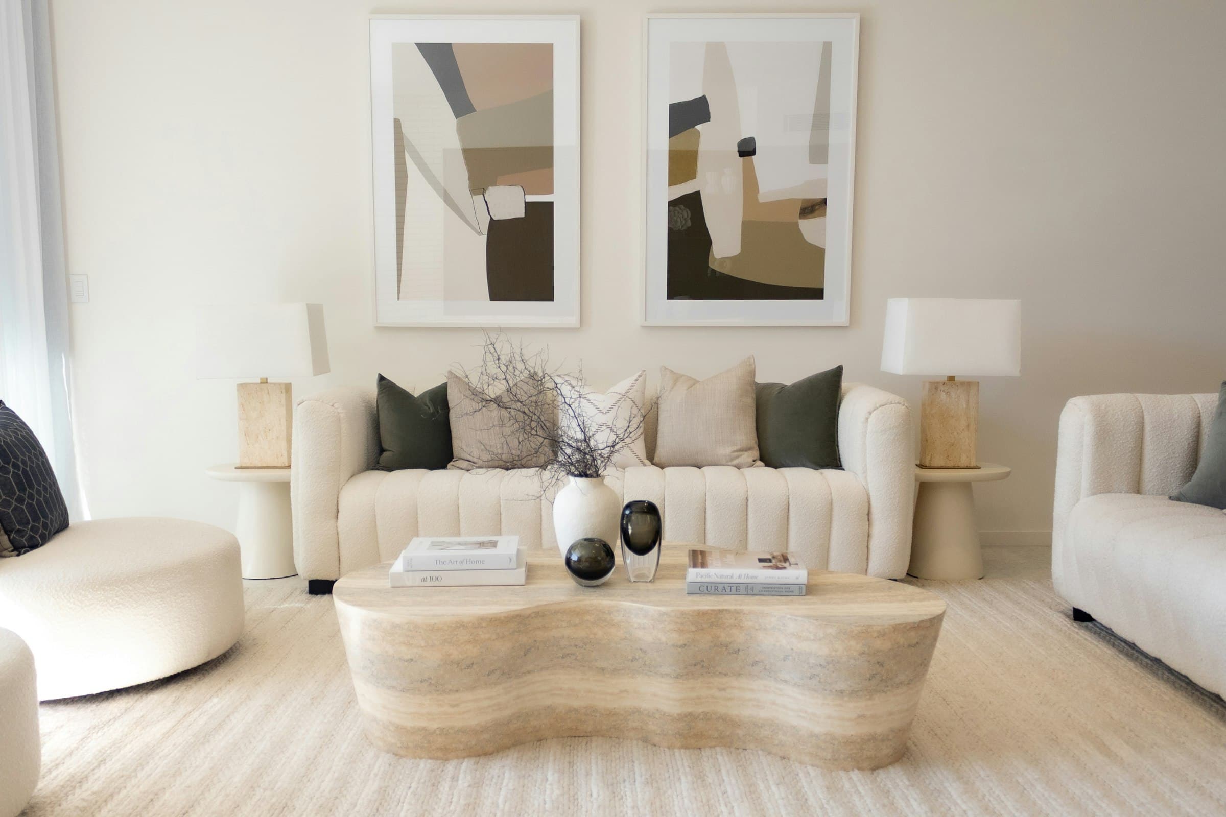 A refined, freshly painted living room in warm neutral tones with designer furnishings